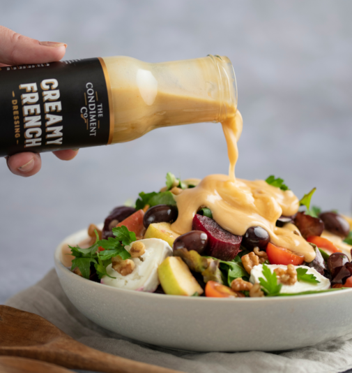 French dressing being poured onto a goats cheese salad